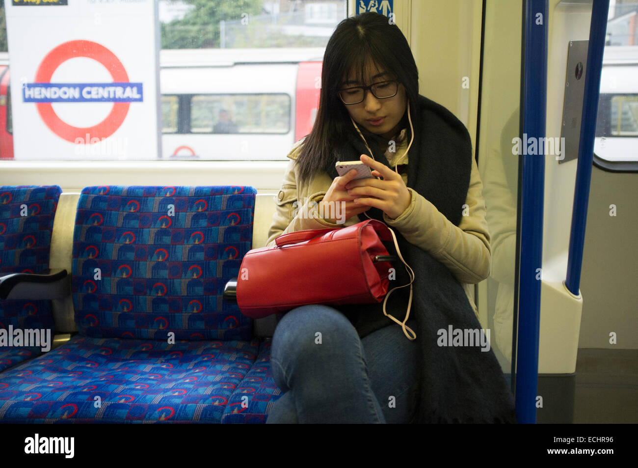 Asian female on her phone on London Underground Stock Photo