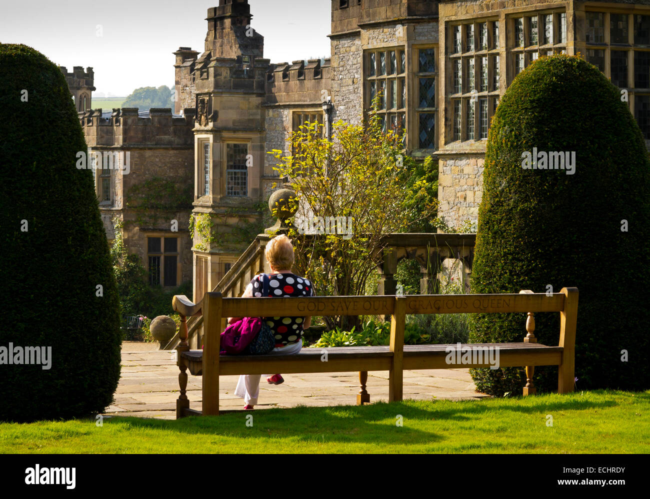 Woman on bench in garden at Haddon Hall near Bakewell in the Peak