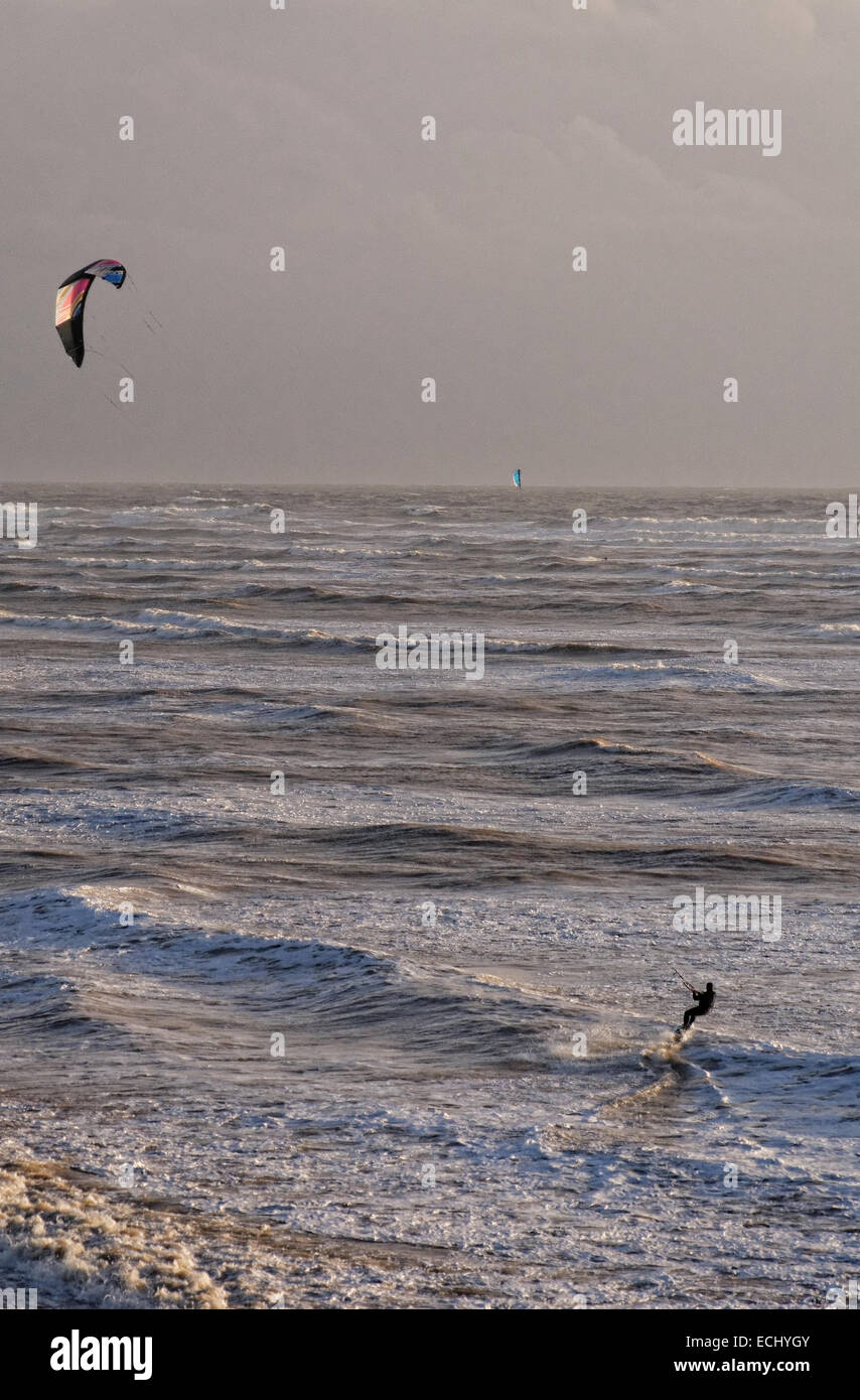 A single sailboarder harnesses the wind and speeds across the white surf at Compton Bay, Isle of Wight Stock Photo
