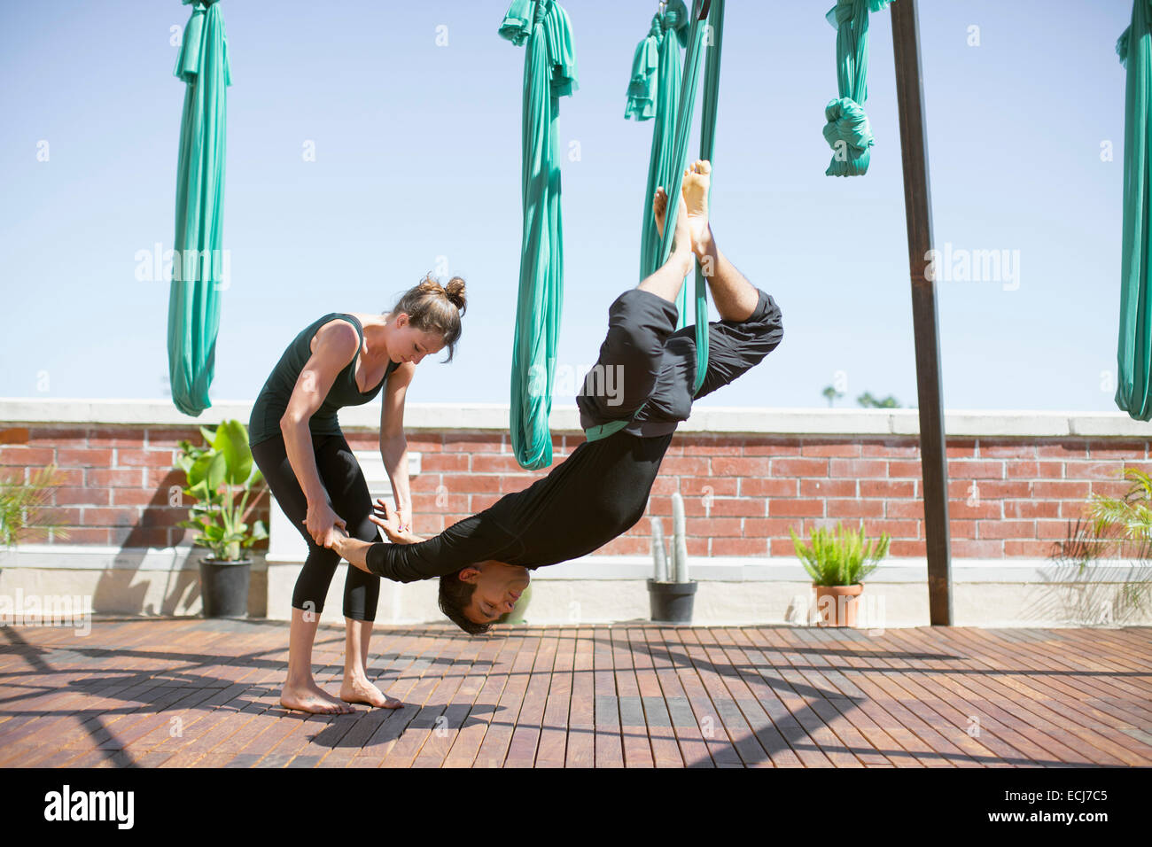A beautiful girls and a young man perform aerial yoga. Stock Photo