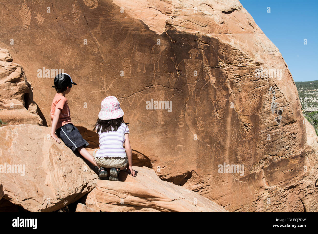 5-year-old boy-girl twins study a wall of pictographs. Stock Photo