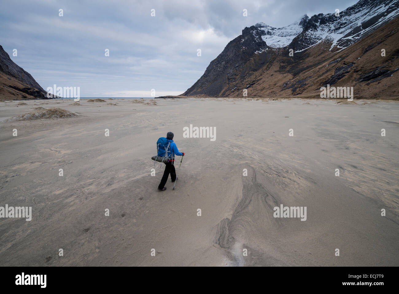 Female backpacker walks across the vast sands of Horseid beach, Moskenesøy, Lofoten Islands, Norway Stock Photo