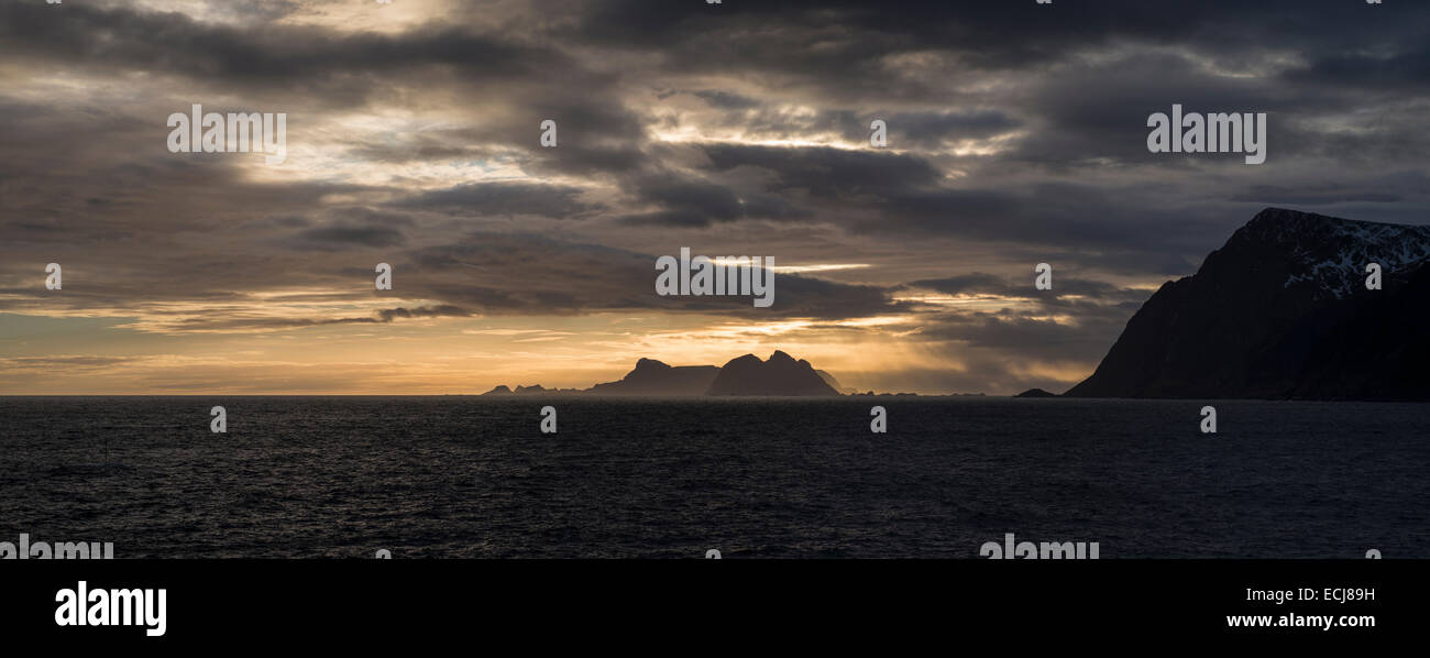 Værøy islands rise over sea while illuminated by winter sunset, Moskenesøy, Lofoten Islands, Norway Stock Photo