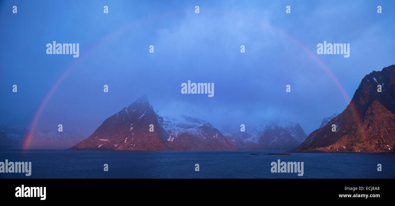 Rainbow forms over Olstind mountain peak and Fjord, Reine, Moskenesøy, Lofoten Islands, Norway Stock Photo