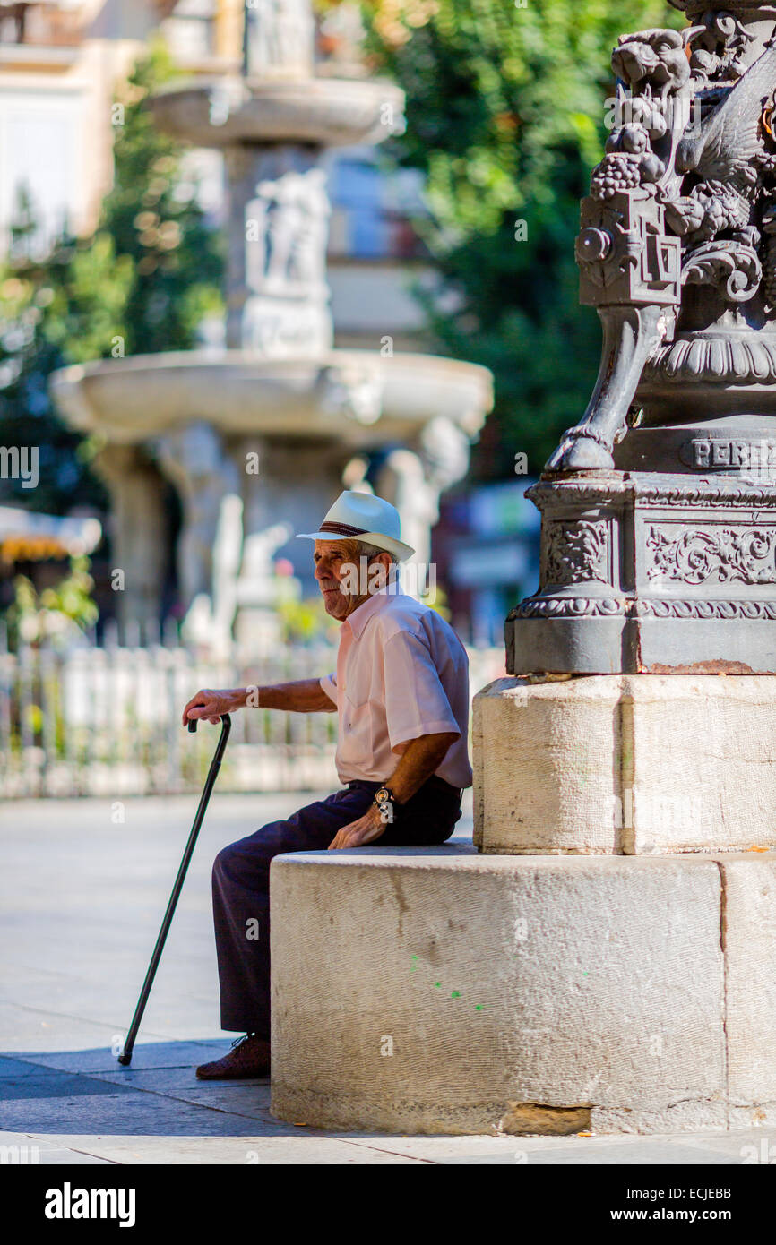 Man resting in the shade of a statue, Malaga Spain Stock Photo