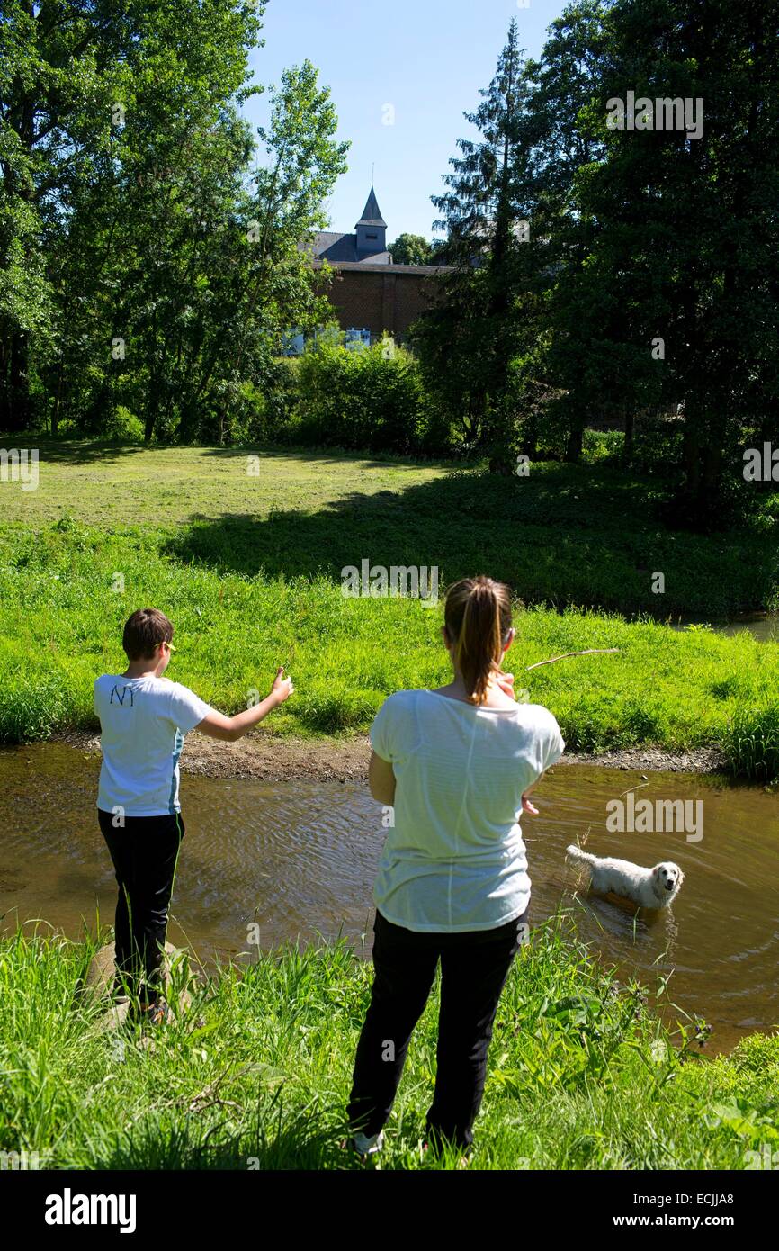 France, Aisne, Ohis, children playing with dog Stock Photo