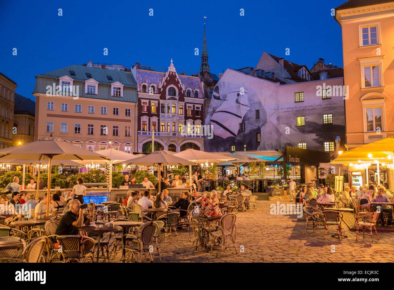 Latvia (Baltic States), Riga, European capital of culture 2014, historical centre listed as World Heritage by UNESCO, terrasses in the city center, street Tirgonu with a view of the church bell tower Saint Peter Stock Photo