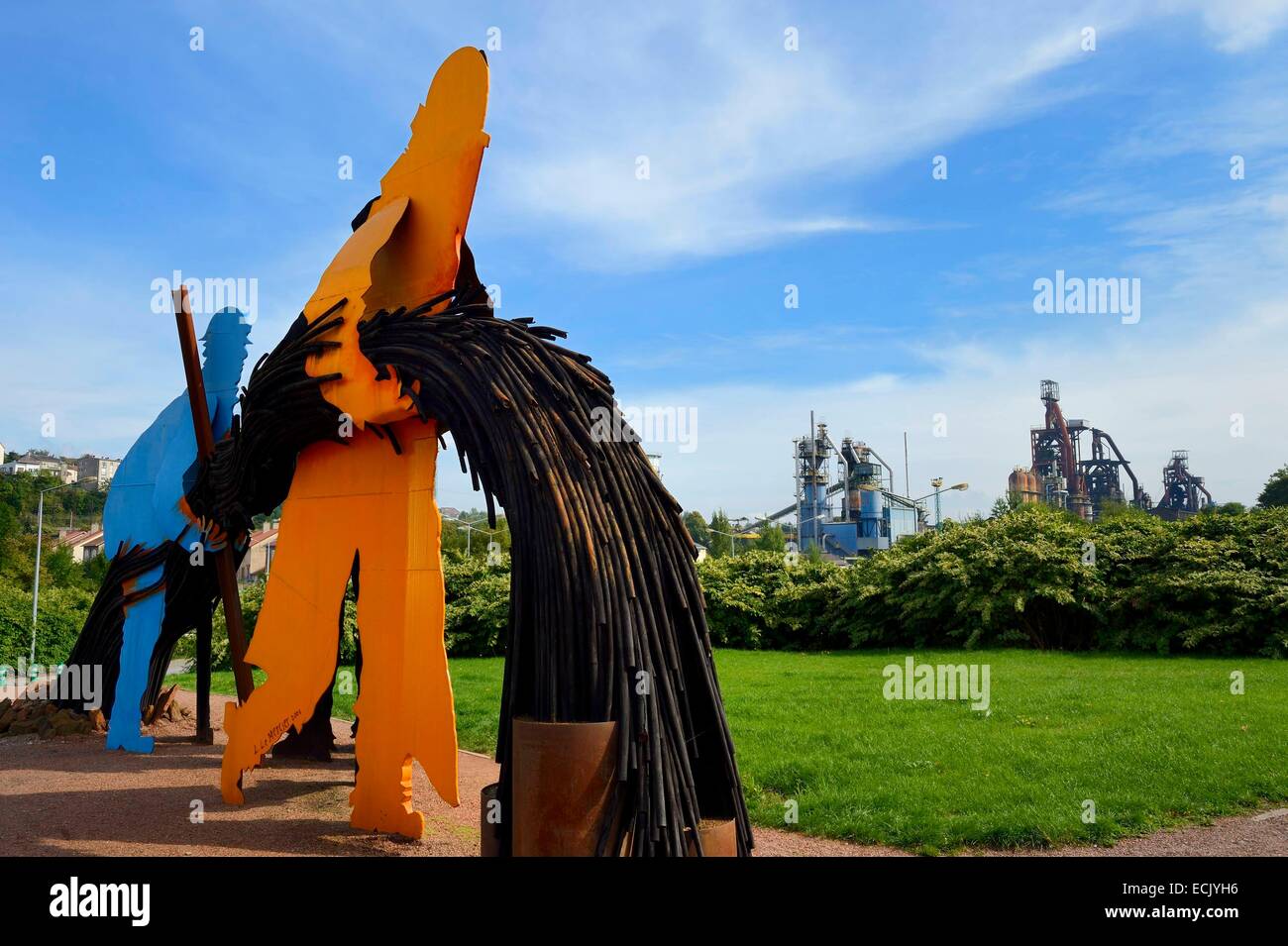 France, Moselle, Fensch Valley, Hayange, Luc Mercier sculpture with the last Blast furnaces (known as of Florange) of ArcelorMittal in the background Stock Photo