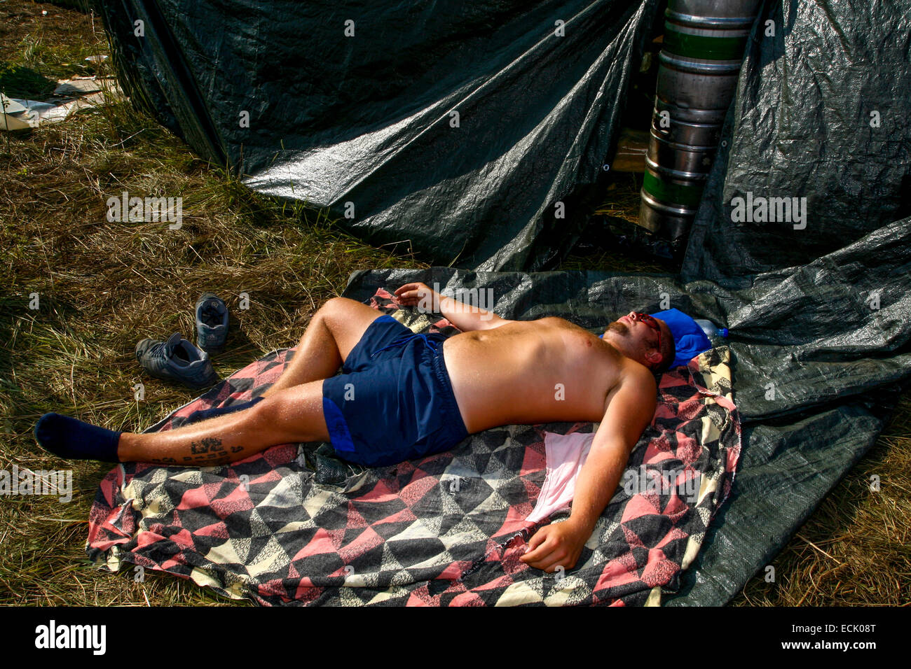 Drunk man asleep on blanket Czech techno music festival Czech Republic Stock Photo