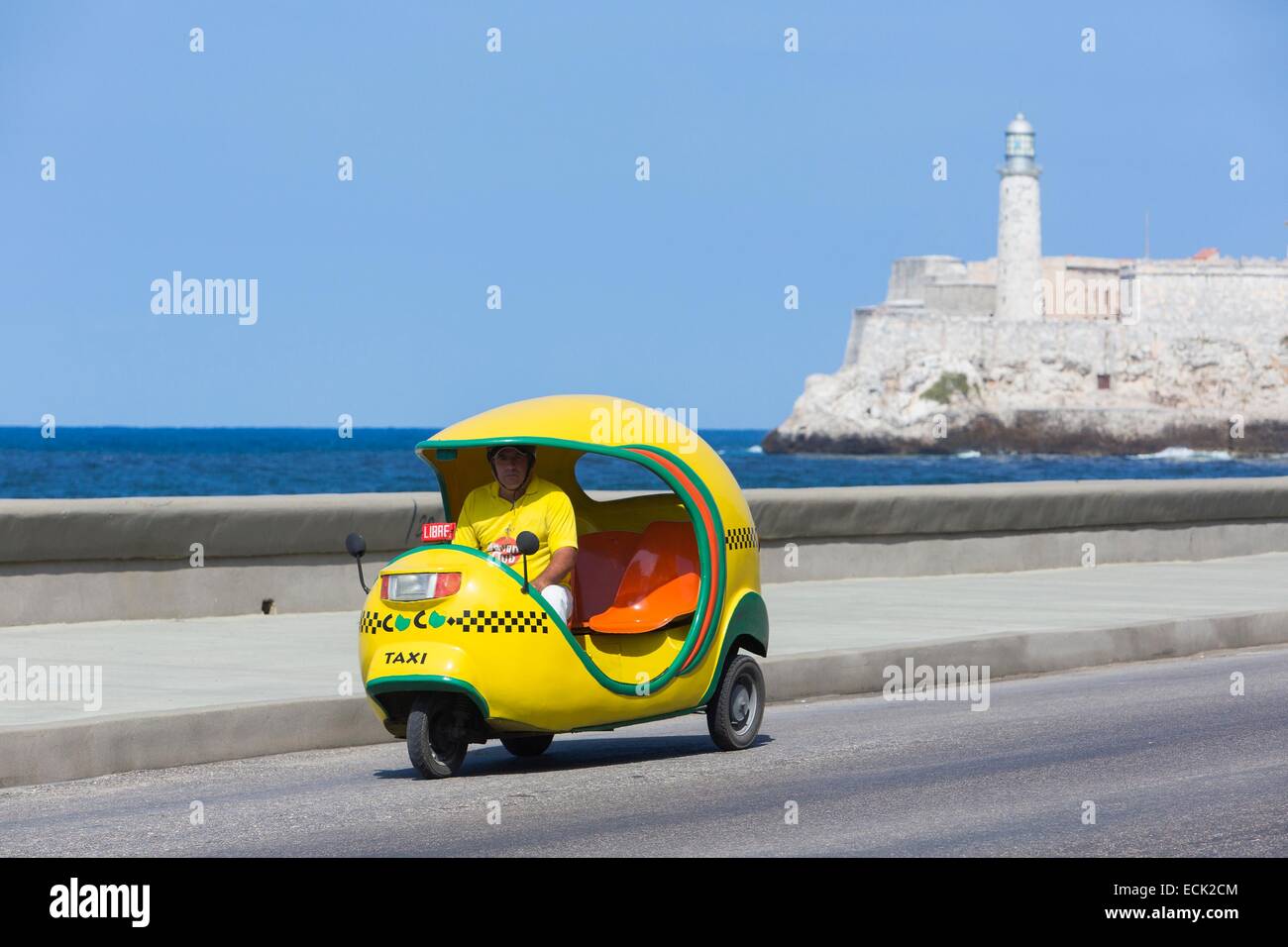 Cuba, La Habana, coco taxi on the Malecon and Castillo de los Tres Reyes Magos del Moro in the background Stock Photo