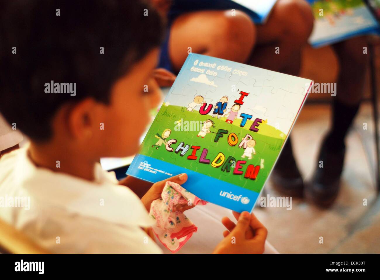 Sri Lanka, Colombo, children in uniform looking at Unicef children book