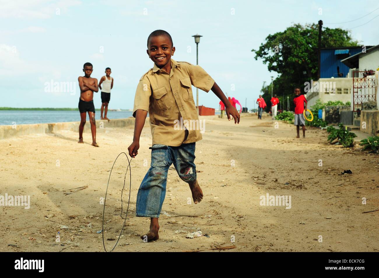 Kenya, Lamu archipelago, Lamu, local boy playing with wheel of bicycle