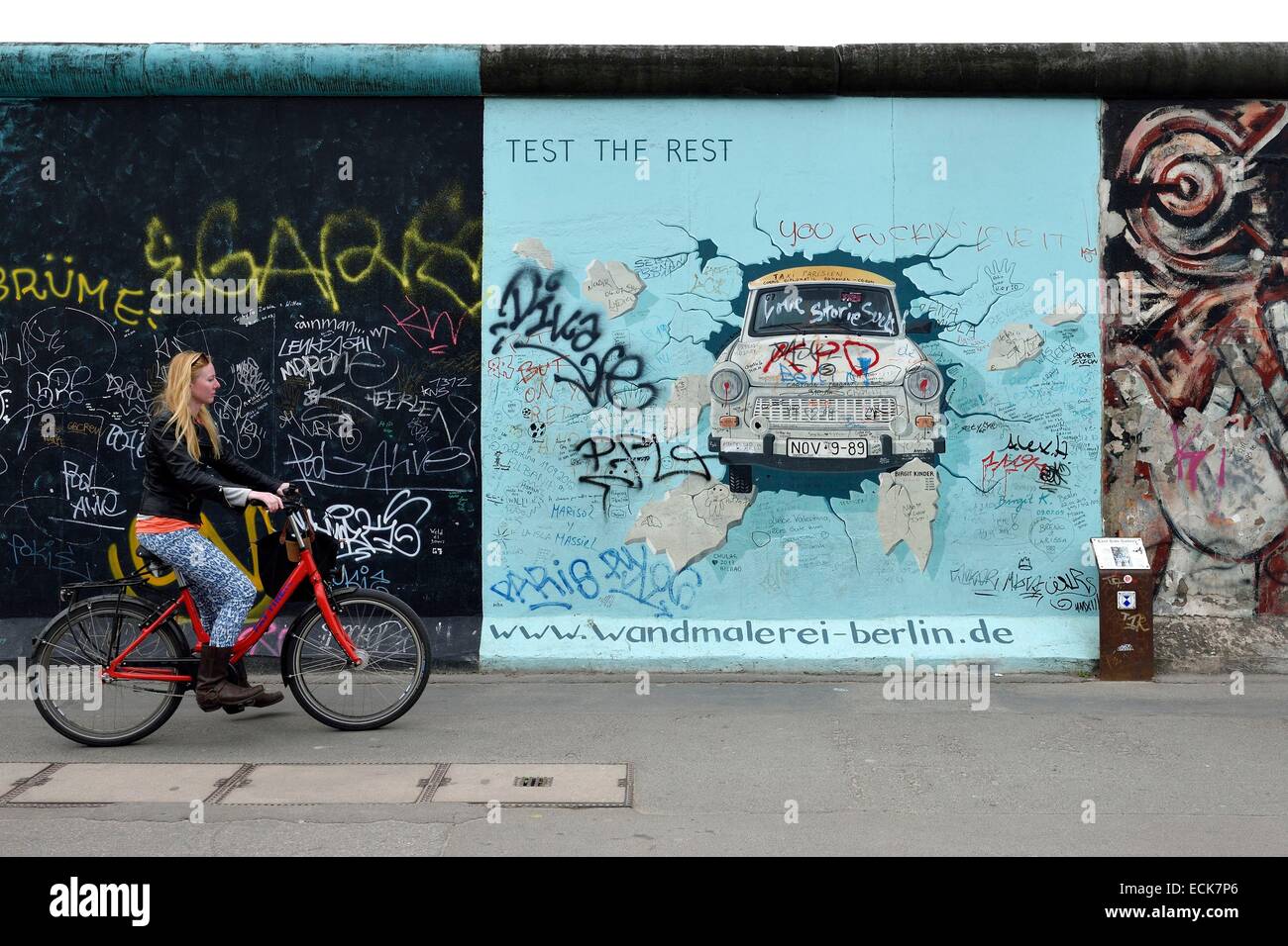 Germany, Berlin, Friedrichshain-Kreuzberg, East Side Gallery, The Wall, work by Birgit Kinder dating from the 1990's, renovated in 2009, representing a Trabant arriving in East Berlin, entitled Test the Best Stock Photo