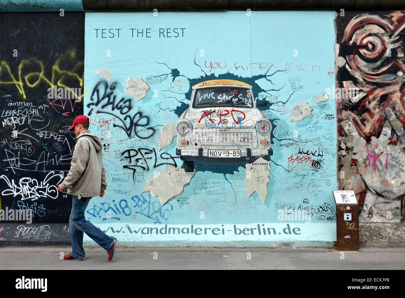 Germany, Berlin, Friedrichshain-Kreuzberg, East Side Gallery, The Wall, work by Birgit Kinder dating from the 1990's, renovated in 2009, representing a Trabant arriving in East Berlin, entitled Test the Best Stock Photo