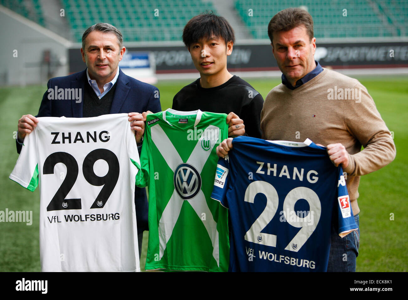 (141216) -- WOLFSBURG, Dec. 16, 2014 (Xinhua) -- Zhang Xizhe (C) of China, Wolfsburg's head coach Dieter Hecking (R) and Wolfsburg' s manager Klaus Allofs display Zhang Xizhe's jerseys after a press conference in Wolfsburg, Germany, on Dec. 16, 2014. German Bundesliga's VfL Wolfsburg announced the signing of Chinese midfielder Zhang Xizhe on Tuesday in Wolfsburg. (Xinhua/Zhang Fan) Stock Photo