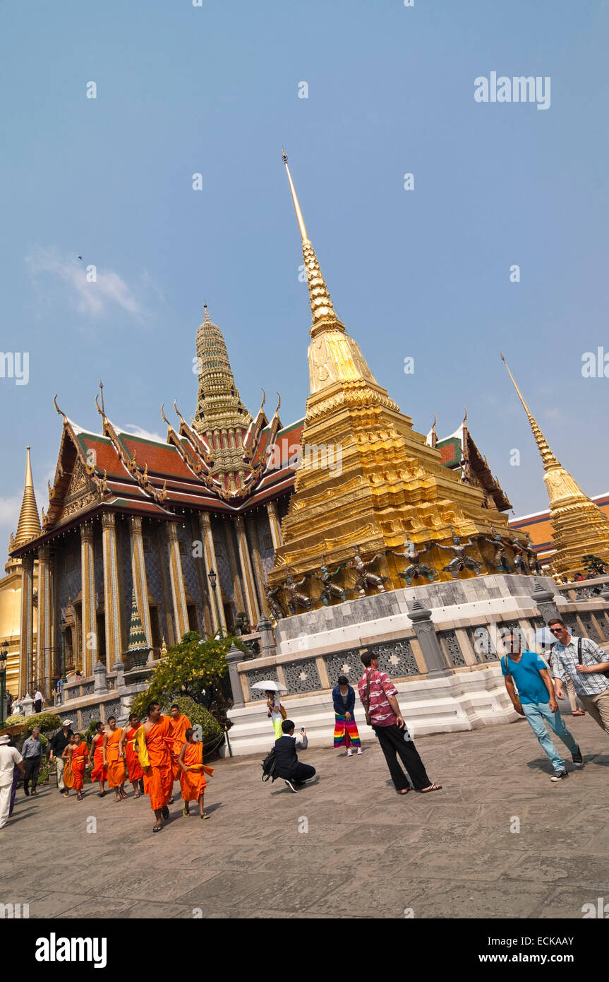 Vertical view of Buddhist monks walking passed the Royal Pantheon inside the Grand Palace in Bangkok. Stock Photo