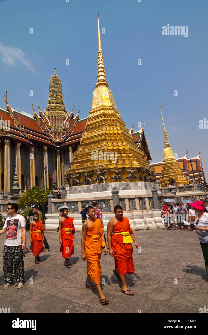 Vertical view of Buddhist monks walking passed the Royal Pantheon inside the Grand Palace in Bangkok. Stock Photo