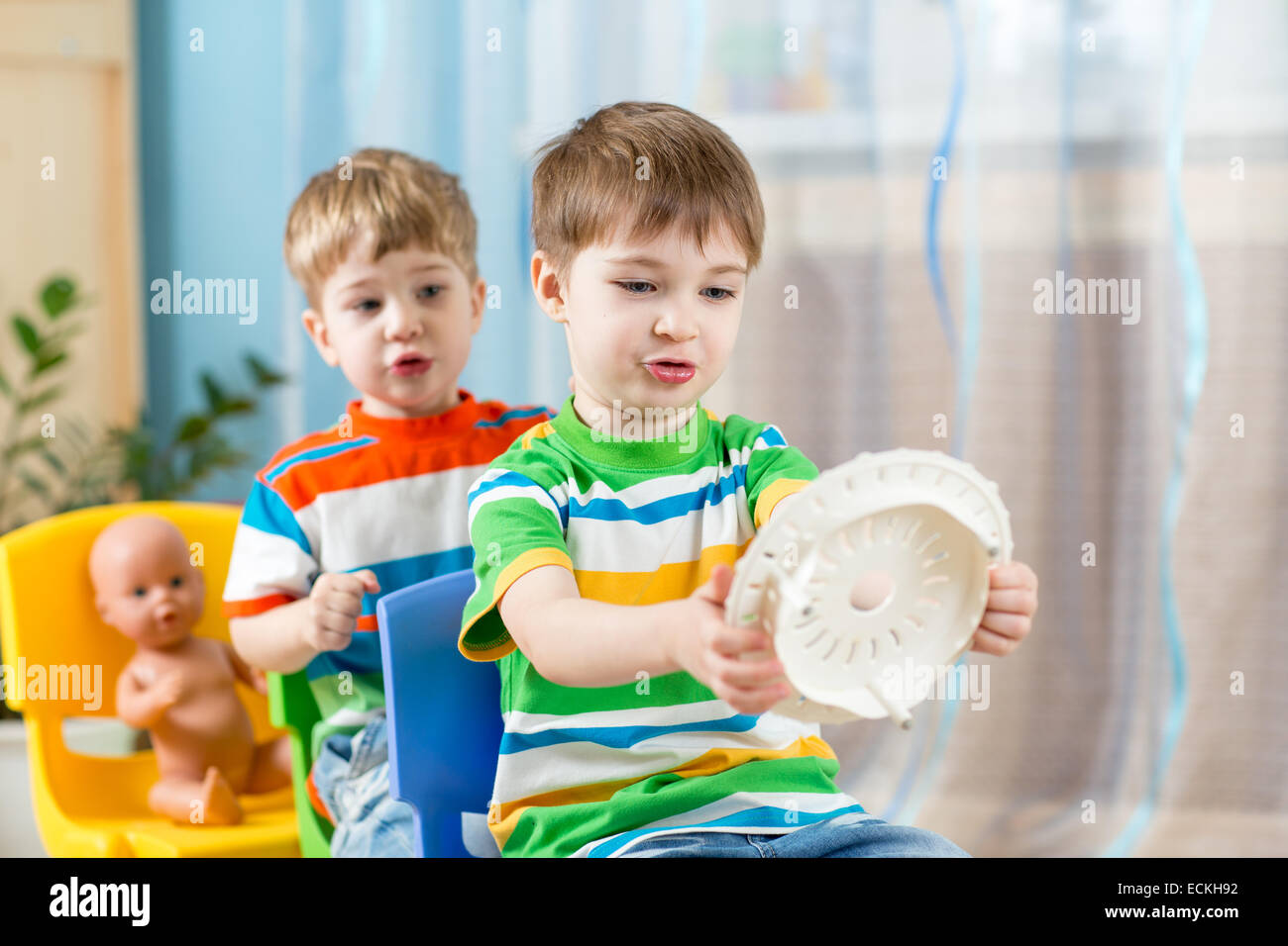 kids boys playing role game and riding on carriages made from chairs Stock Photo