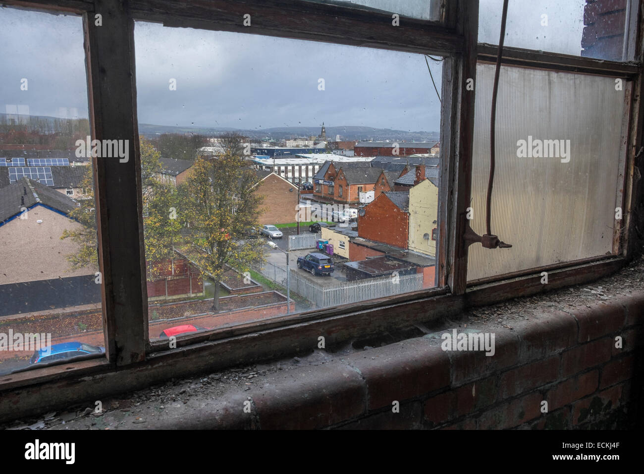 Looking out through a wet and dirty window across the tops of houses