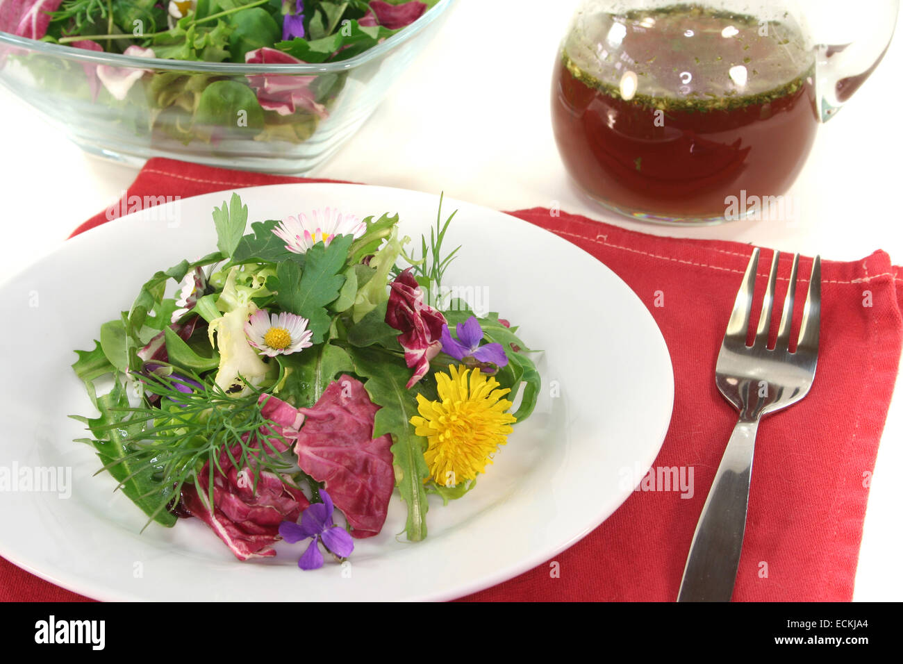 Wild herb salad with balsamic oil dressing on a white background Stock