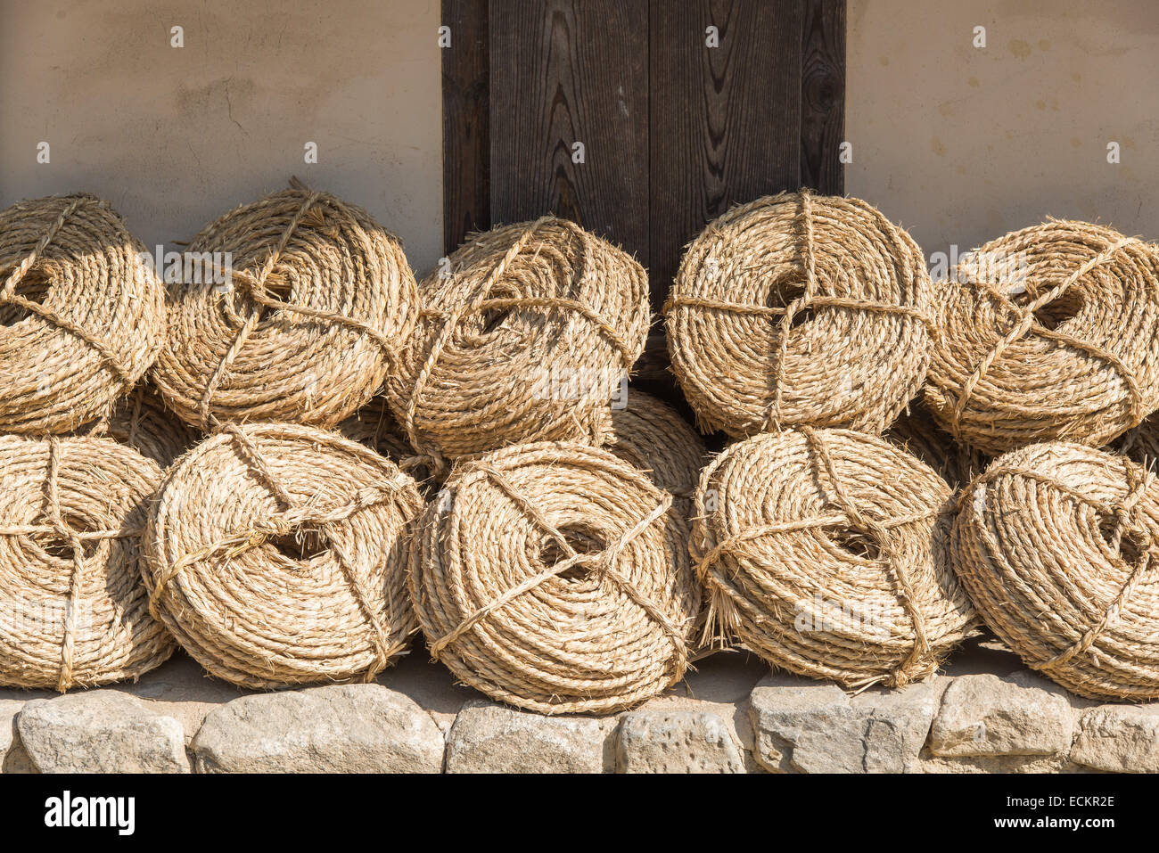 bunches of straw ropes, leaned against a wall Stock Photo