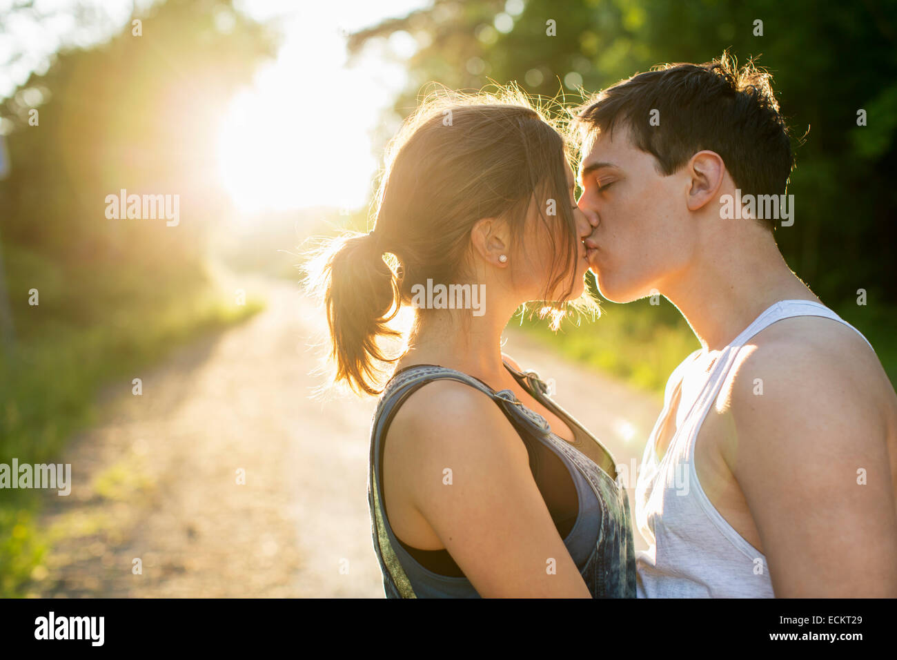 Two Teenage Girls Kissing Teen High Resolution Stock Photography And   Couple Kissing On Dirt Road Against Bright Sun ECKT29 