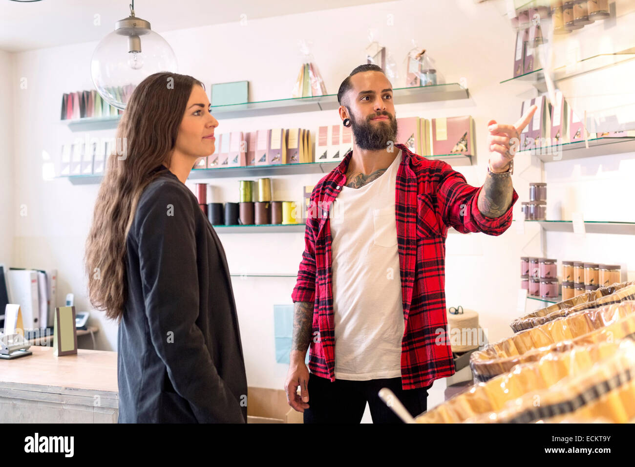 Owner showing products to customer in candy store Stock Photo Alamy
