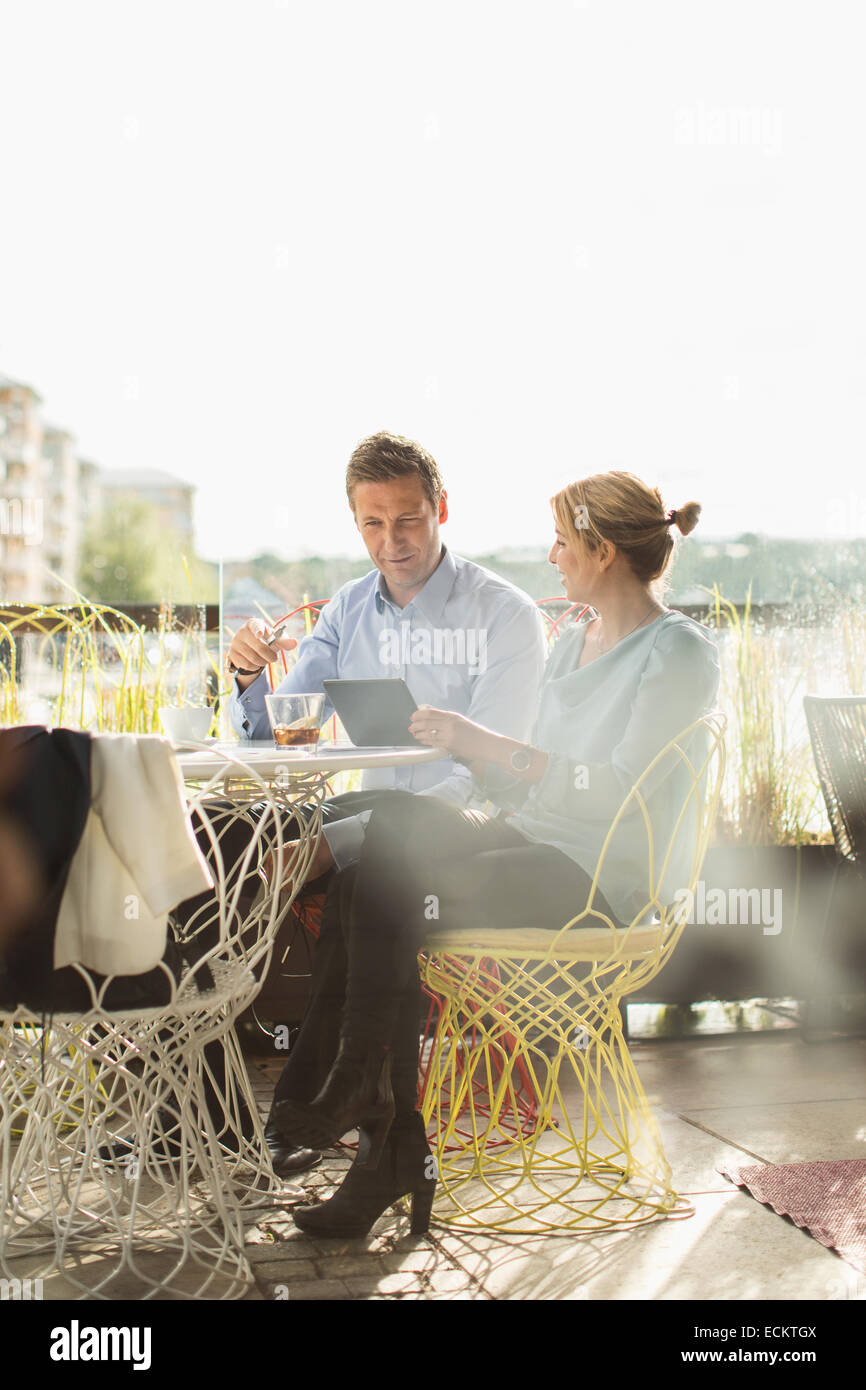 Business people using digital tablet in cafe against clear sky Stock Photo