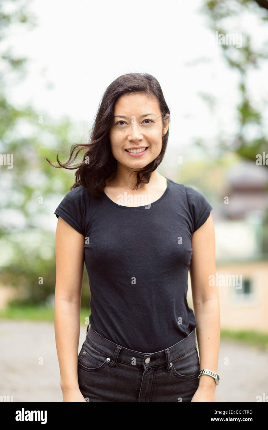 Portrait of smiling woman standing on street Stock Photo - Alamy