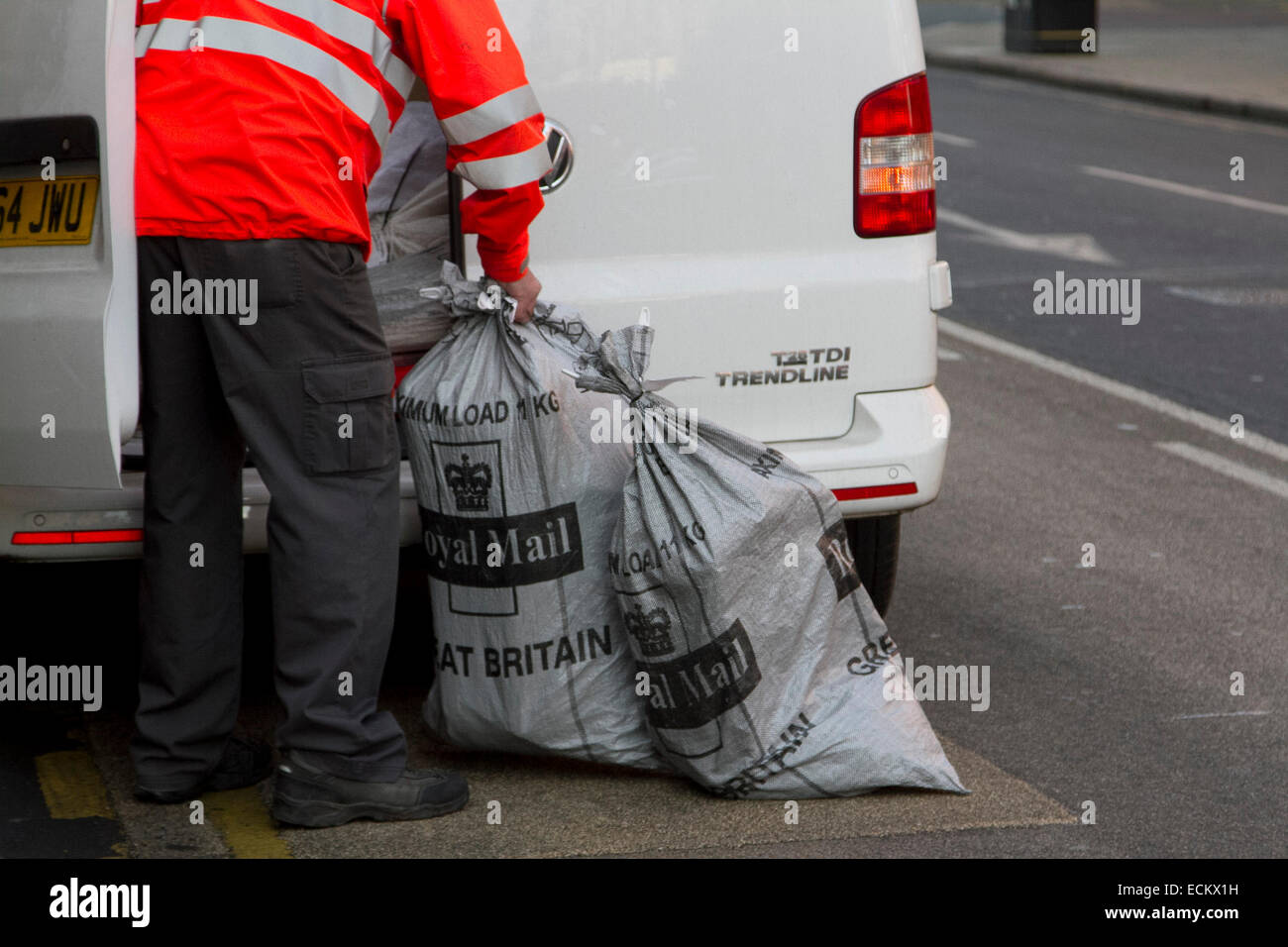 Wimbledon, London, UK. 16th Dec, 2014. A Royal Mail worker carries Christmas post in bags out of a Post Office branch at Wimbledon. Longer queues at the Post Office as people try to get the Christmas post deadline. The longer queues is parlty caused by the closure of thousands of Post Office branches across the United Kingdom Credit:  amer ghazzal/Alamy Live News Stock Photo