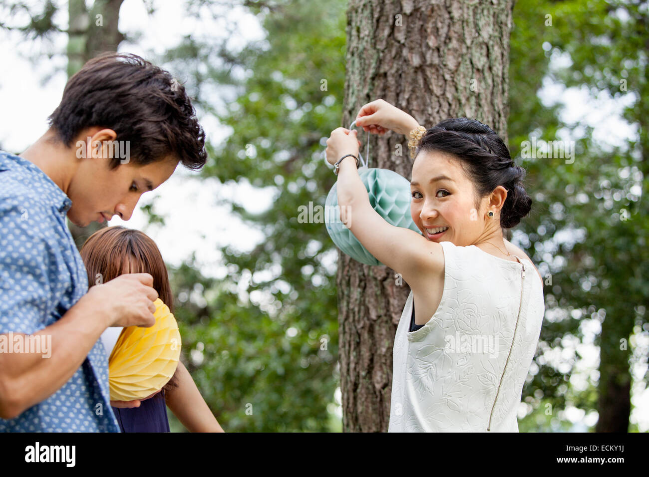 Two people hanging lanterns for a party. Stock Photo