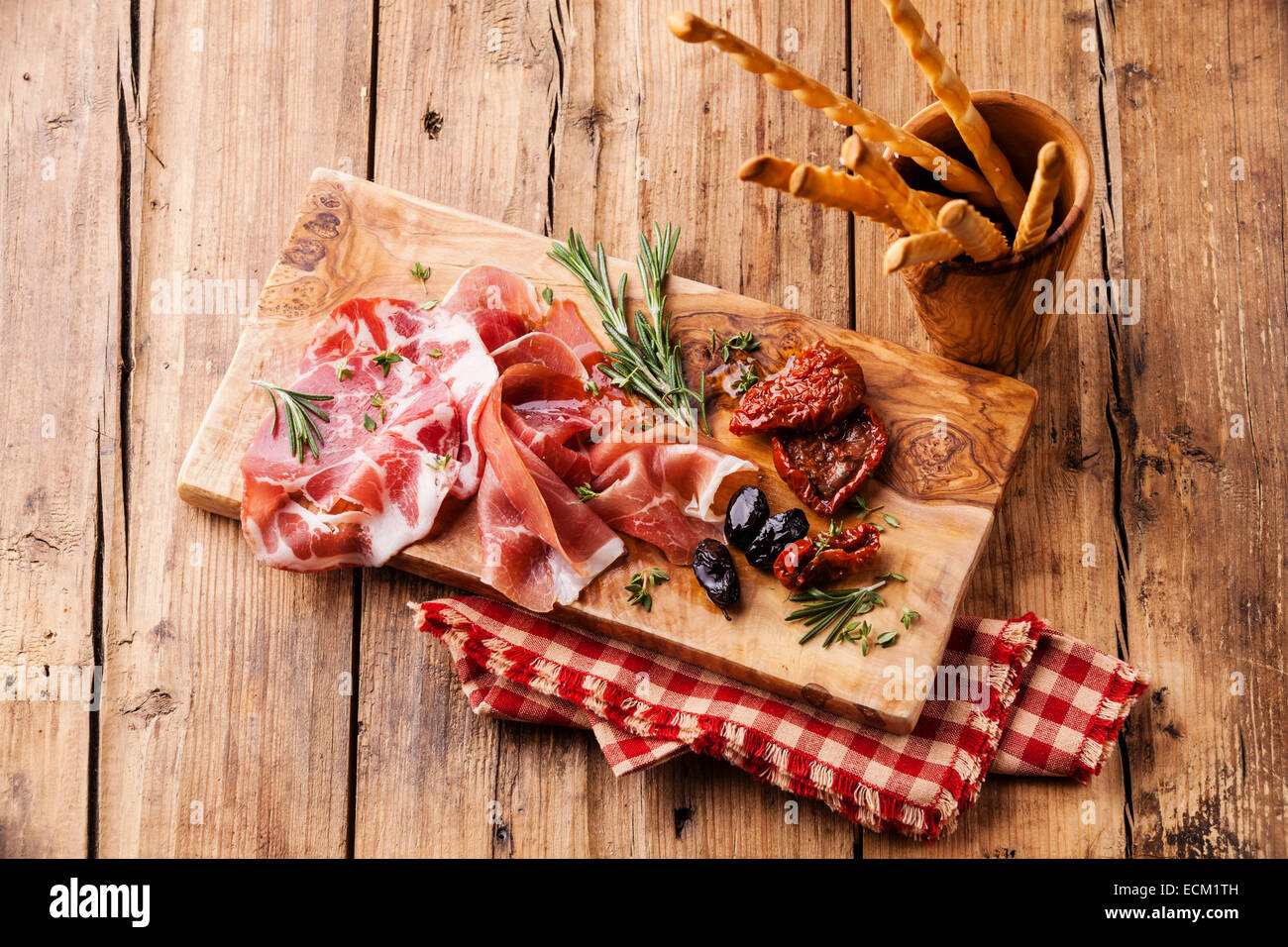 Cold meat plate and bread sticks on wooden background Stock Photo