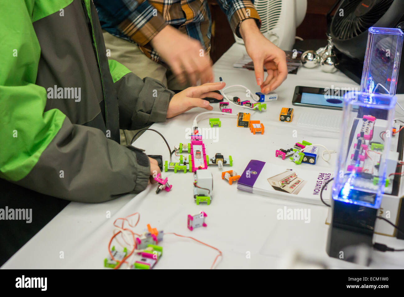 Visitors construct devices at a RadioShack sponsored demonstration of LittleBits technology at an event in New York on Saturday, December 13, 2014. The retailer joined with LittleBits to promote the company's DIY kits which enable you to automate your household gadgets to connect to the 'Internet of Things' (IoT). Various modules connect together to turn your analog appliances into cloud connected smart appliances. RadioShack sells the devices hoping to reinvigorate itself as the go to place for DIY tech geeks. (© Richard B. Levine) Stock Photo