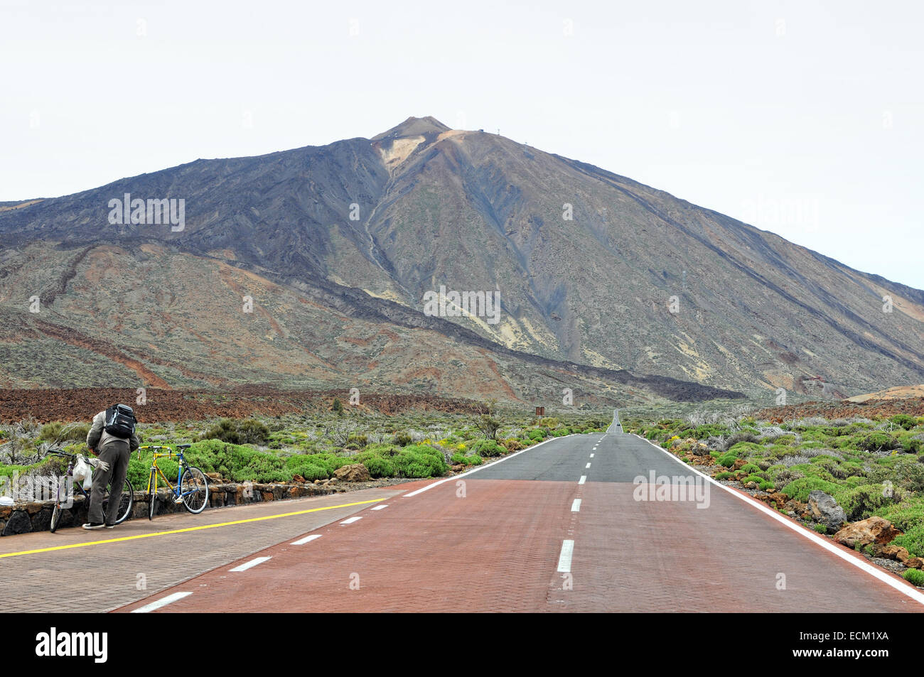 biker resting on road leading towards pico del teide (Tenerife) Stock Photo