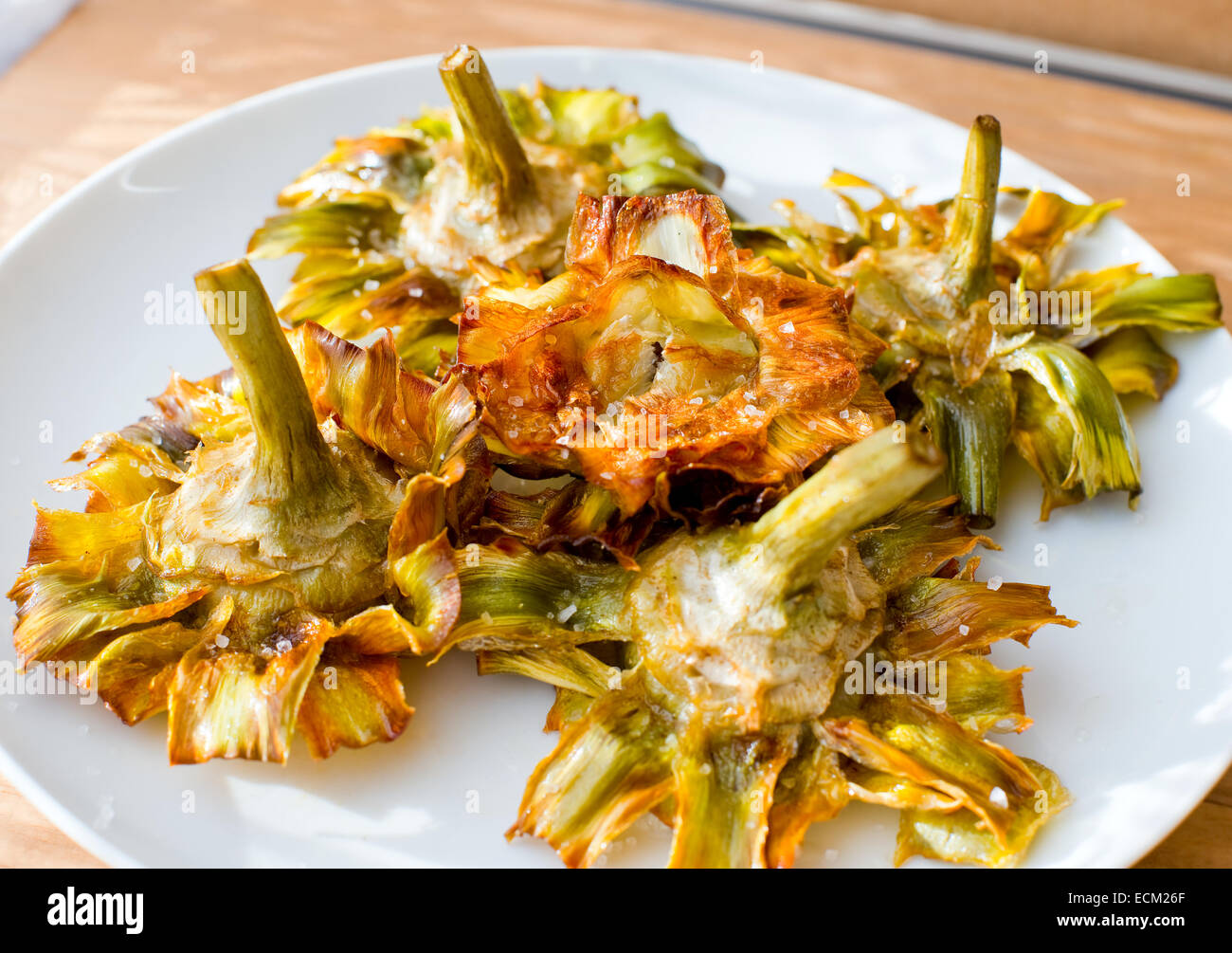 Roman fried artichokes (jewish style) with flakes of sea salt on a