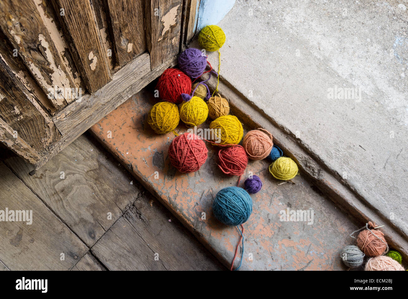 Balls of colored wool in the doorway of an old door Stock Photo