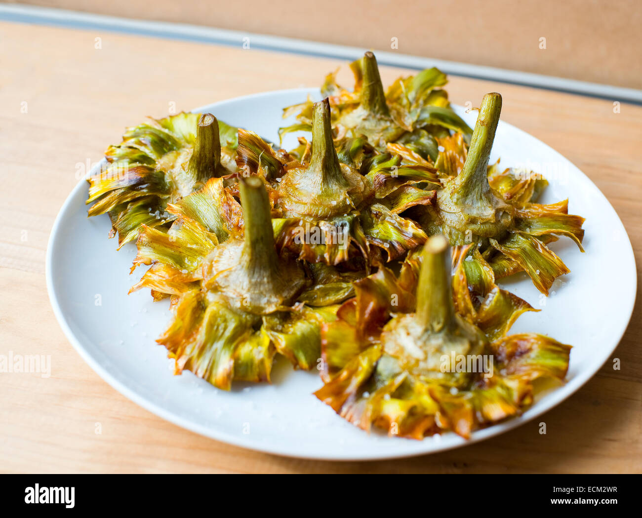 Roman fried artichokes (jewish style) with flakes of sea salt on a