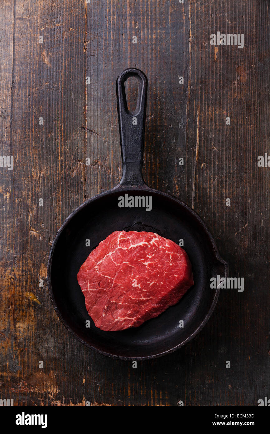 Raw meat Ribeye steak on cast iron frying pan on dark wooden background Stock Photo Alamy
