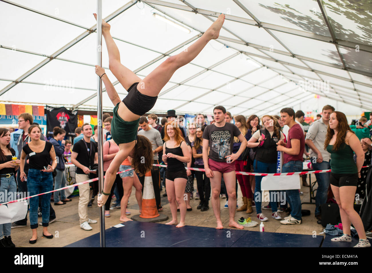 Higher Education: First year undergraduate students watching a fellow student demonstrating pole dancing fitness exercises at the 'freshers fair' at Aberystwyth university at freshers week  on the start of the academic year UK Stock Photo