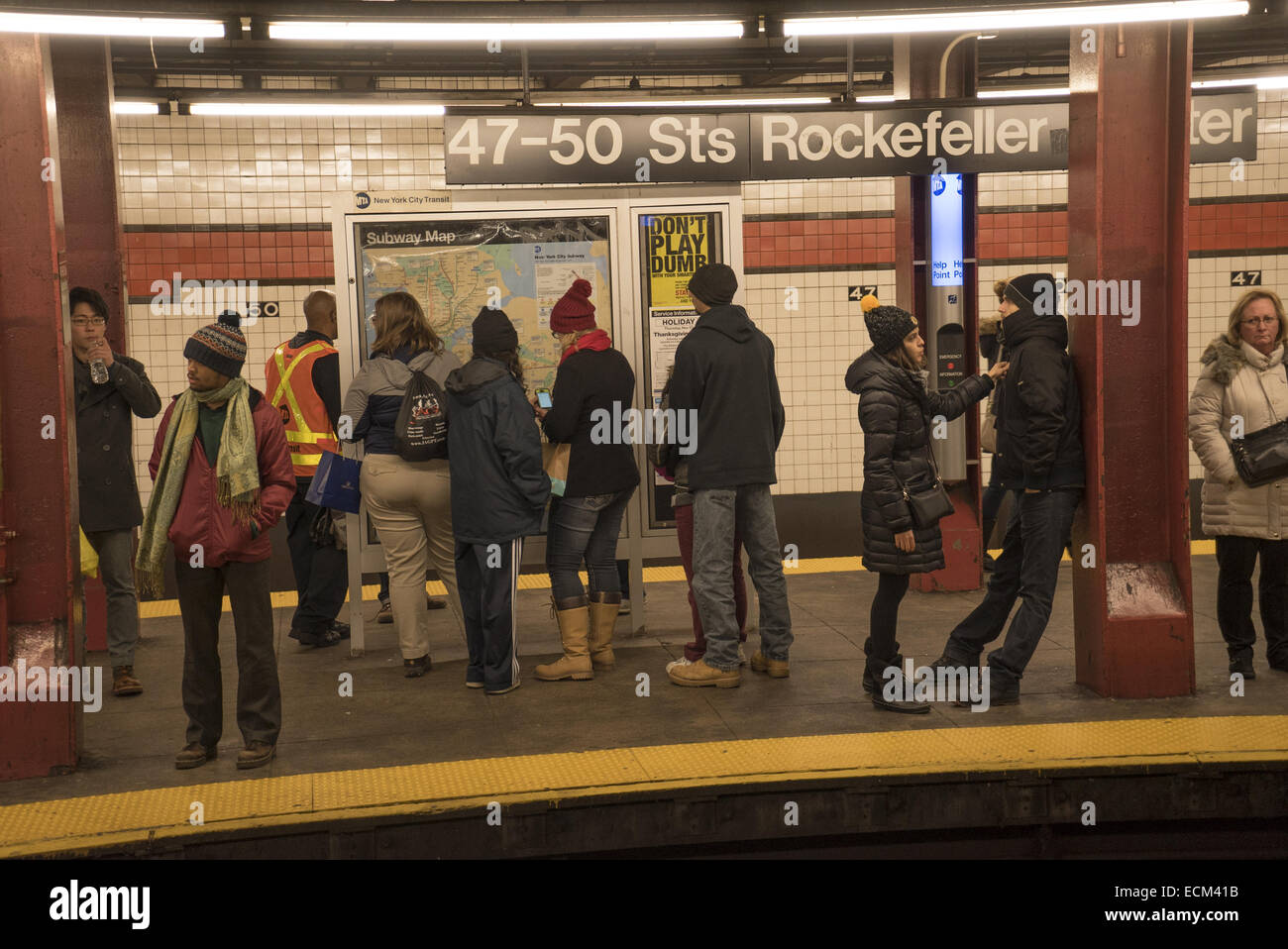 People wait on the subway platform at Rockefeller Center for the next