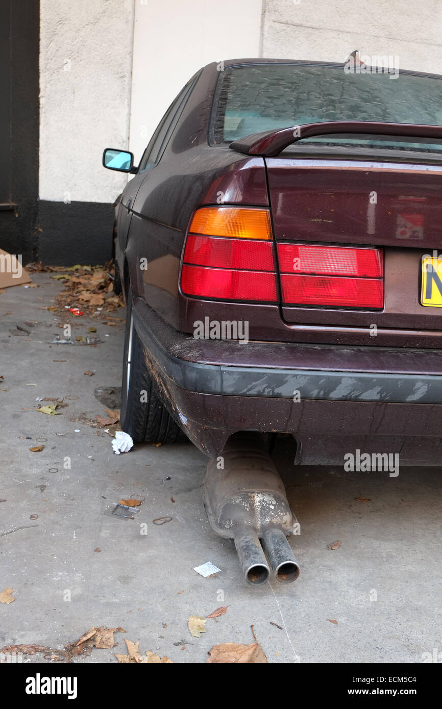 Exhaust falling off an old BMW been dumped on private property in