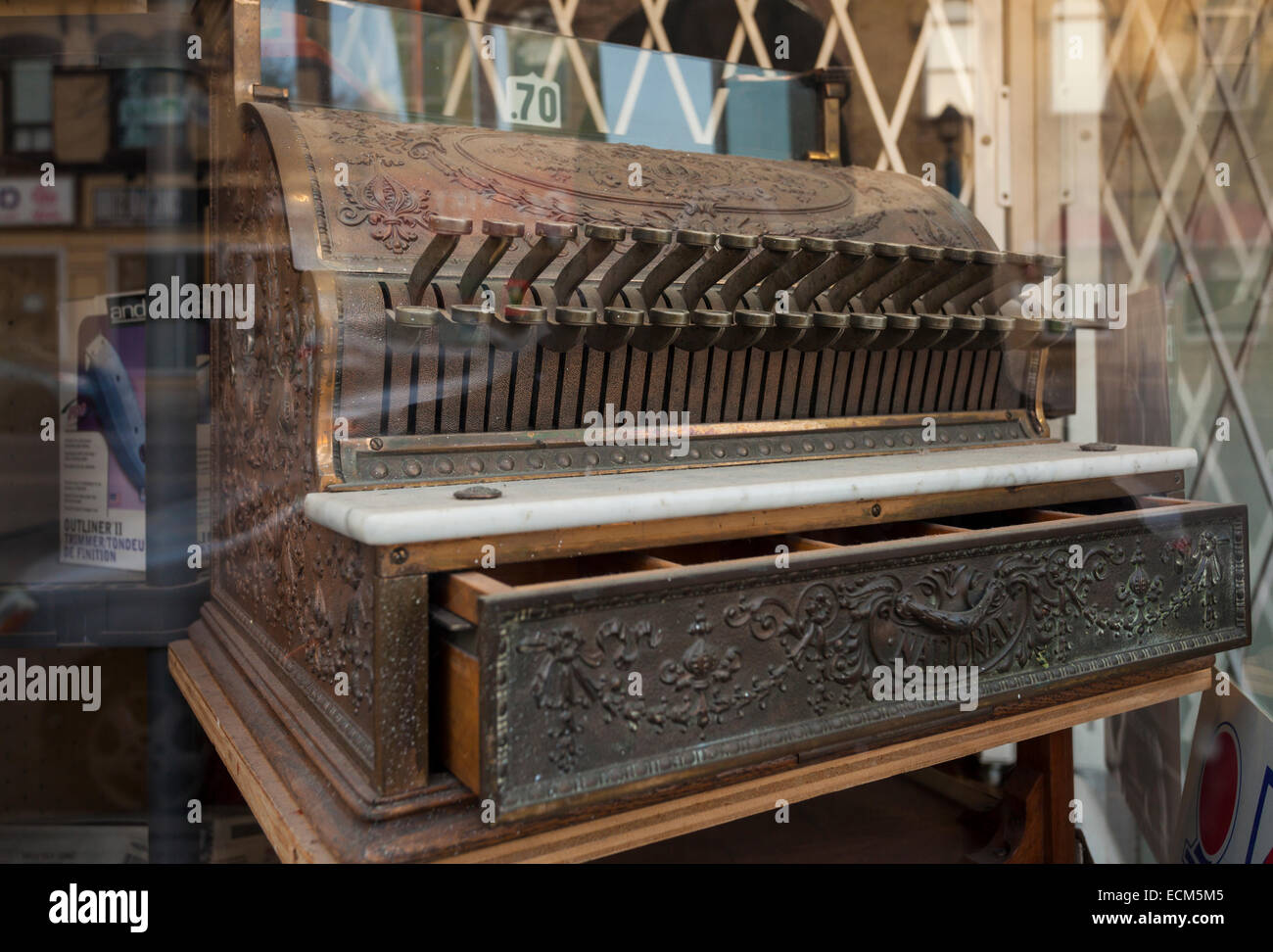 A vintage cash register in the window of a barber shop in downtown Brampton, Ontario, Canada. Stock Photo