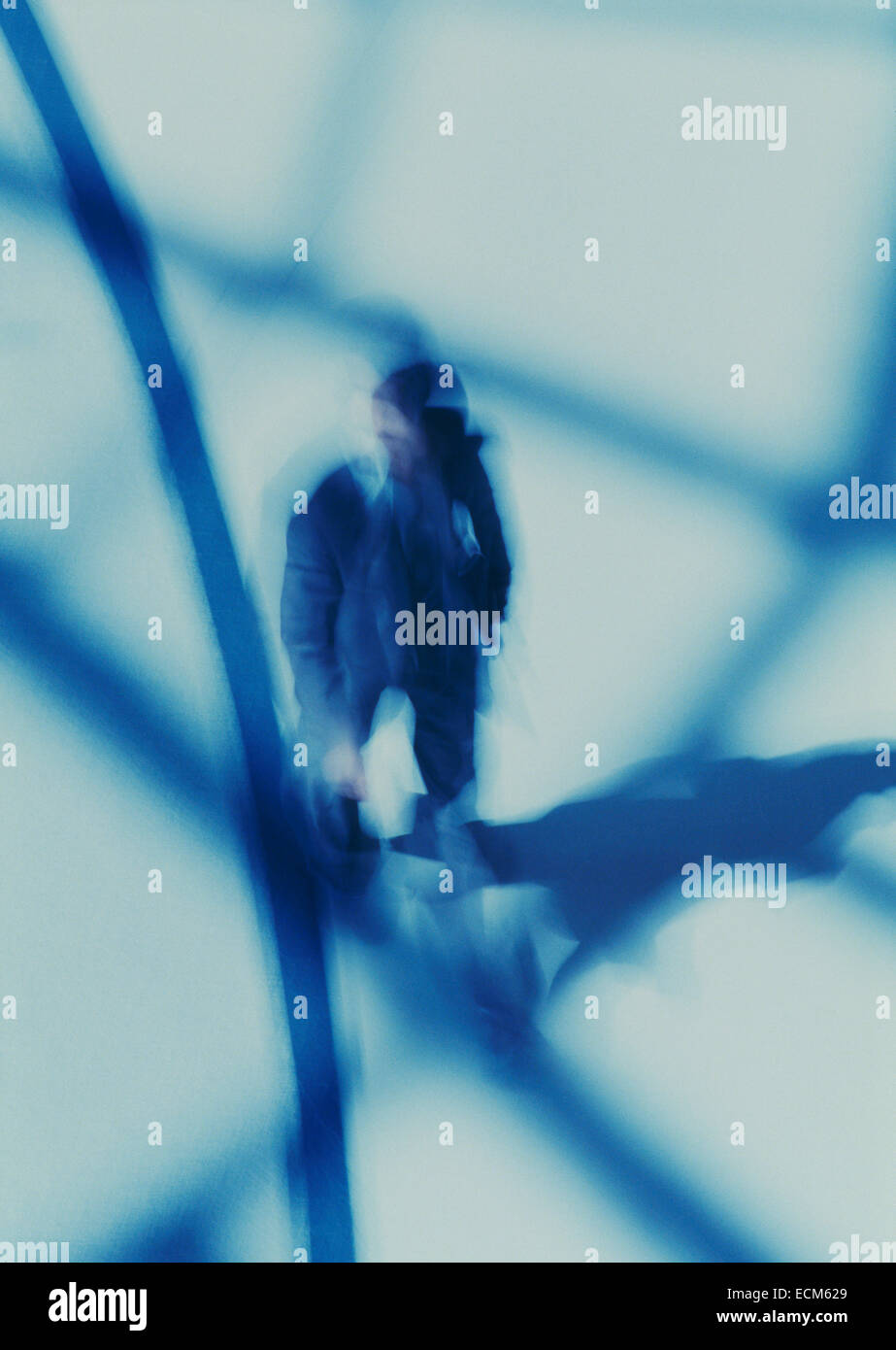 Business man in motion blur as he walks through a brightly lit airport ...