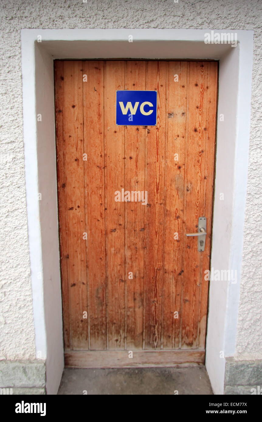 Close up on closed wooden door with WC sign Stock Photo