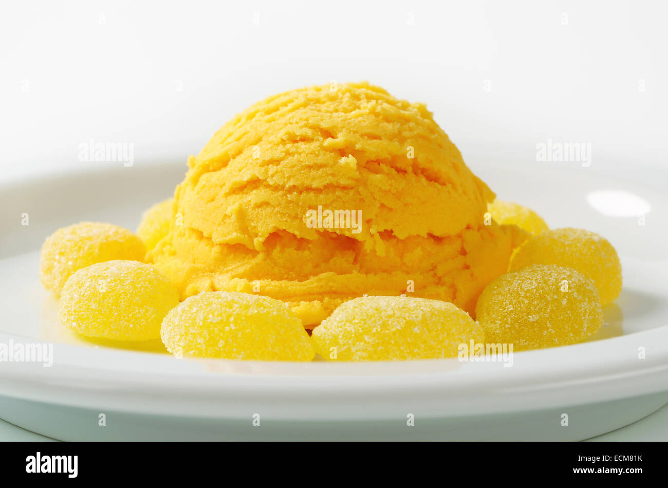 Scoop of yellow ice cream with gelatin-based candy Stock Photo