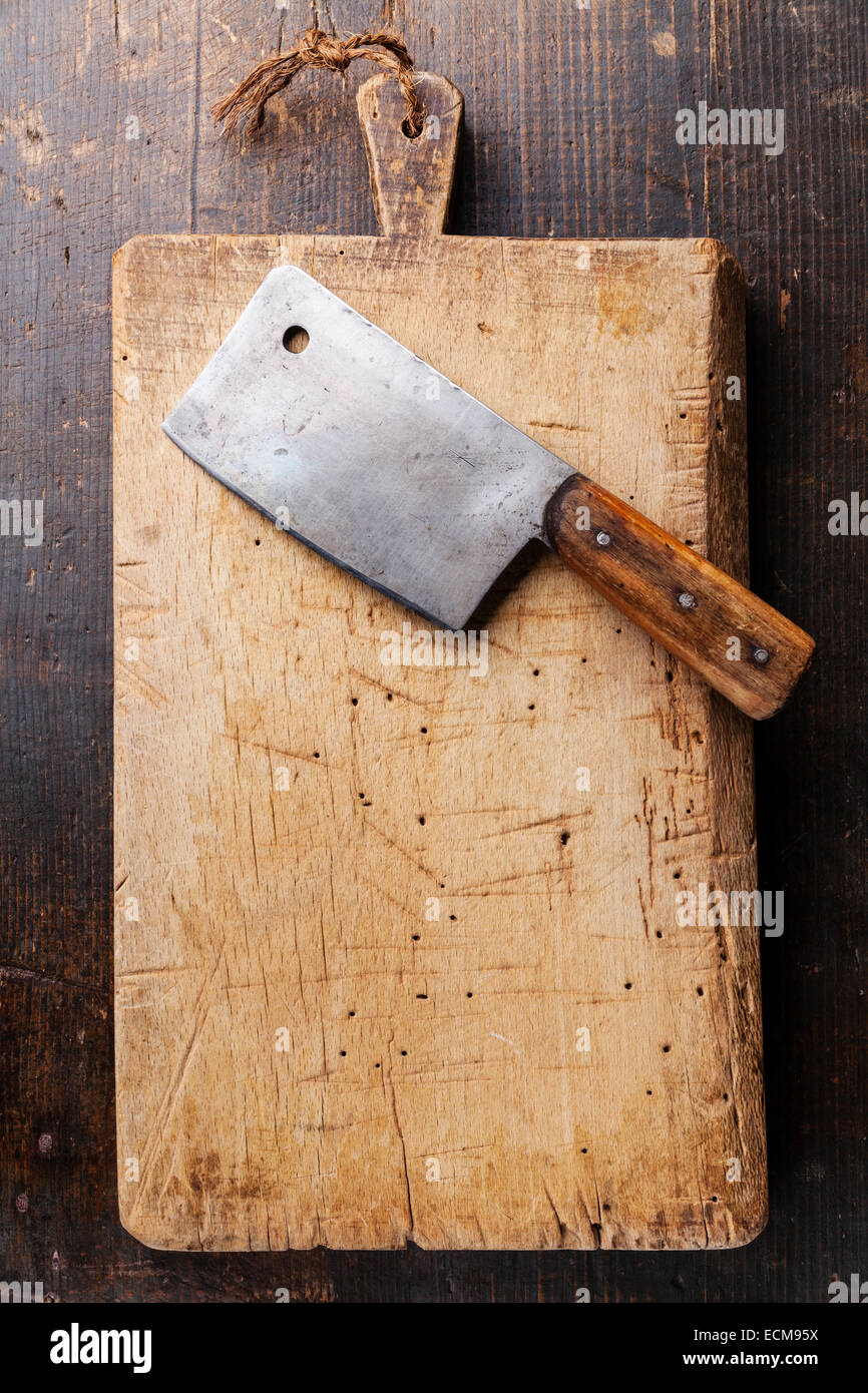 Chopping board and Meat cleaver on dark wooden background Stock Photo