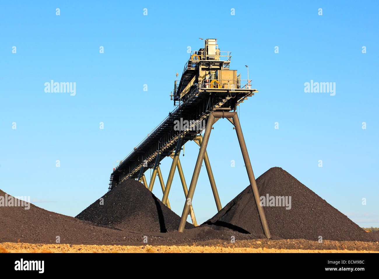 Coal Mining Conveyor Belt and piles of coal with a blue sky background