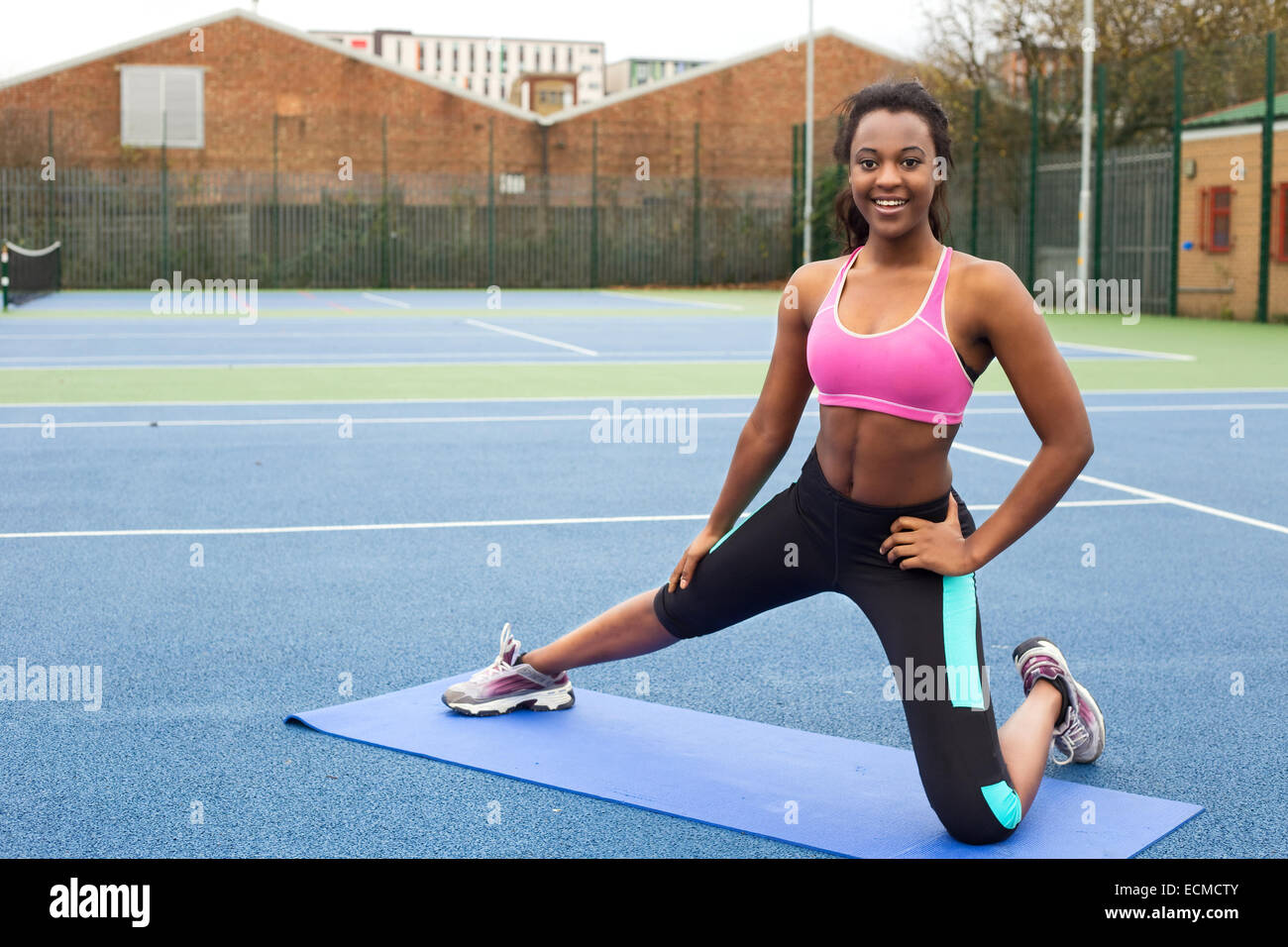 A Sporty Skinny Girl In A Black Workout Tight Suit Is Relaxing After Doing  Push-ups On The Blue Yoga Mat At Home. A Woman Is Practicing Exercises For  The Chest At Her