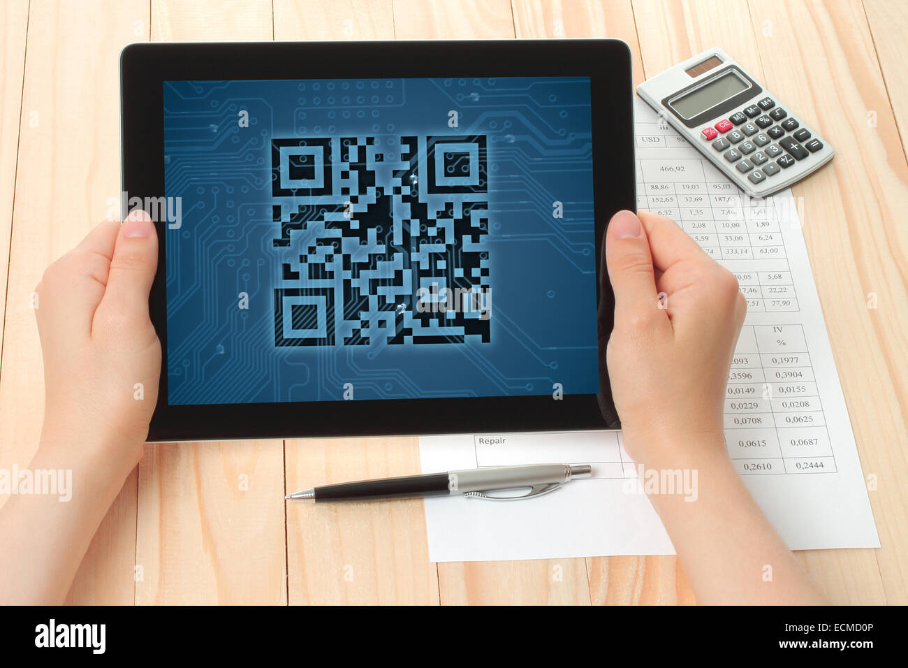 Hands hold tablet PC with QR code on wooden background Stock Photo