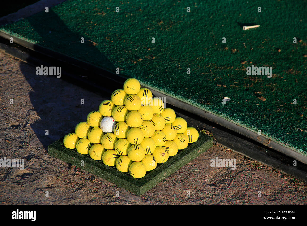 Tropical golf driving range with golf balls stacked in pyramids. Stock Photo